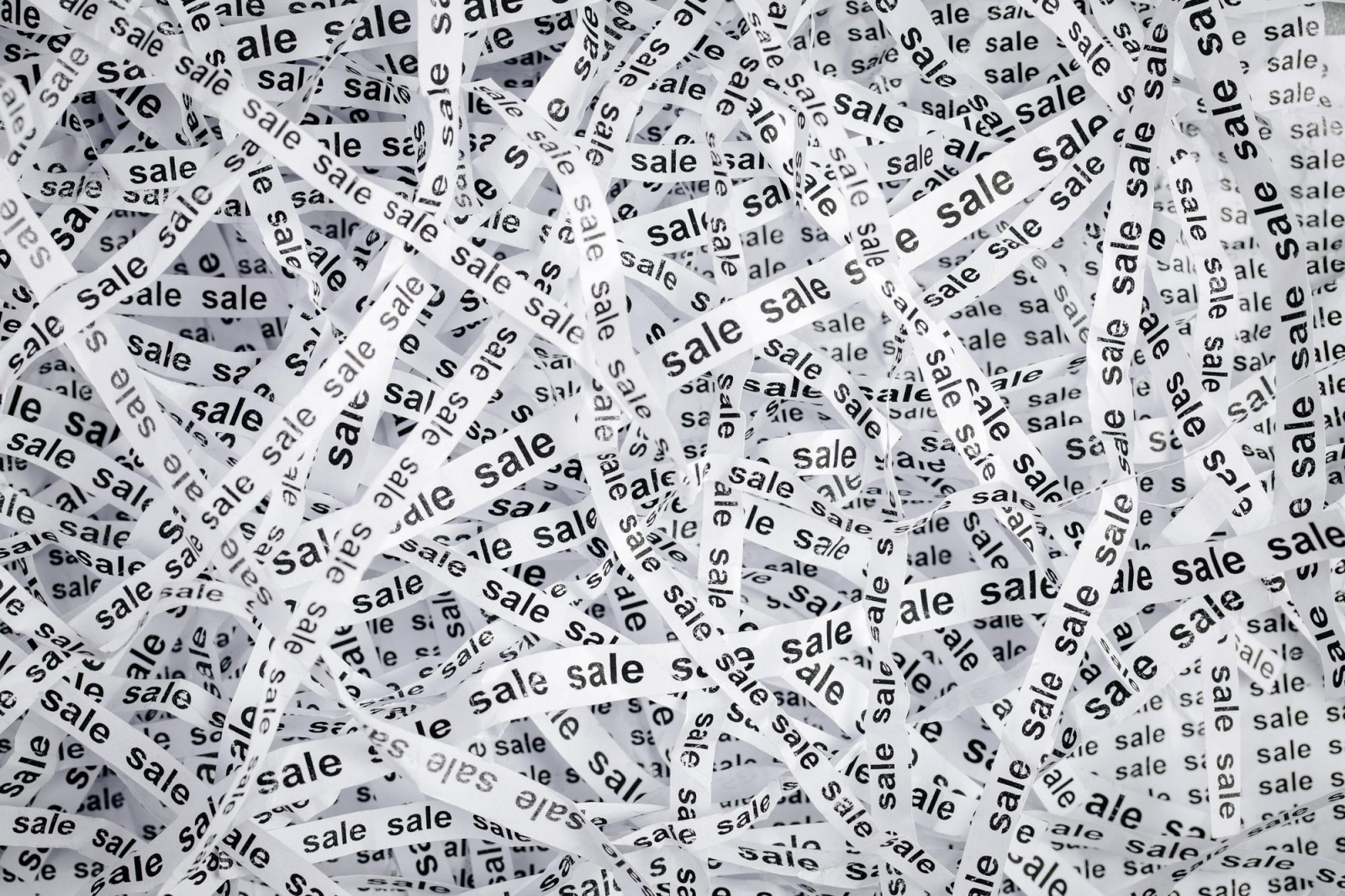 closeup-torn-pieces-tapes-paper-with-word-sale-black-white-image.jpg Фото: множество раз повторяется одно и то же слово